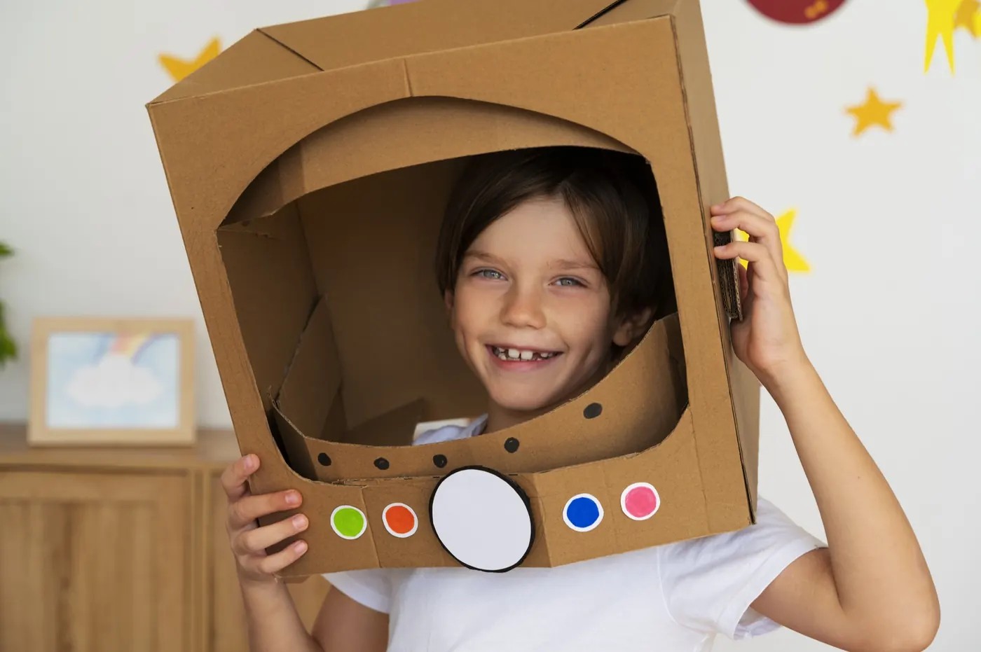 Ein Kind gestaltet einen Astronautenhelm aus Pappe